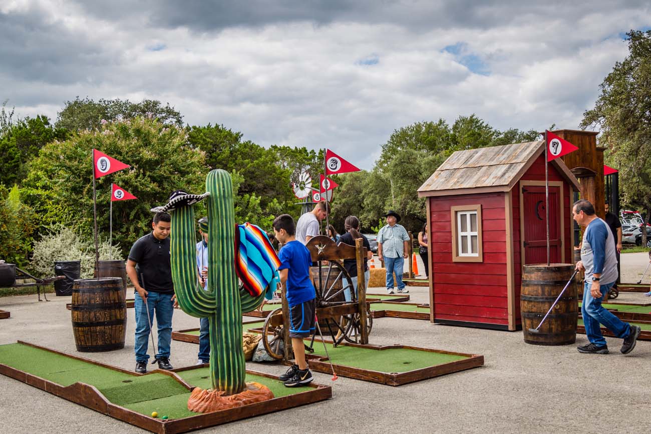 group of people outside playing miniature golf